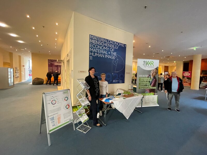 Präsentationsstand des Klinischen Krebsregisters beim Tumortag in Dessau. Zwei Frauen stehen bei dem Stand um Interessierte über die Arbeit des KKR zu informieren.